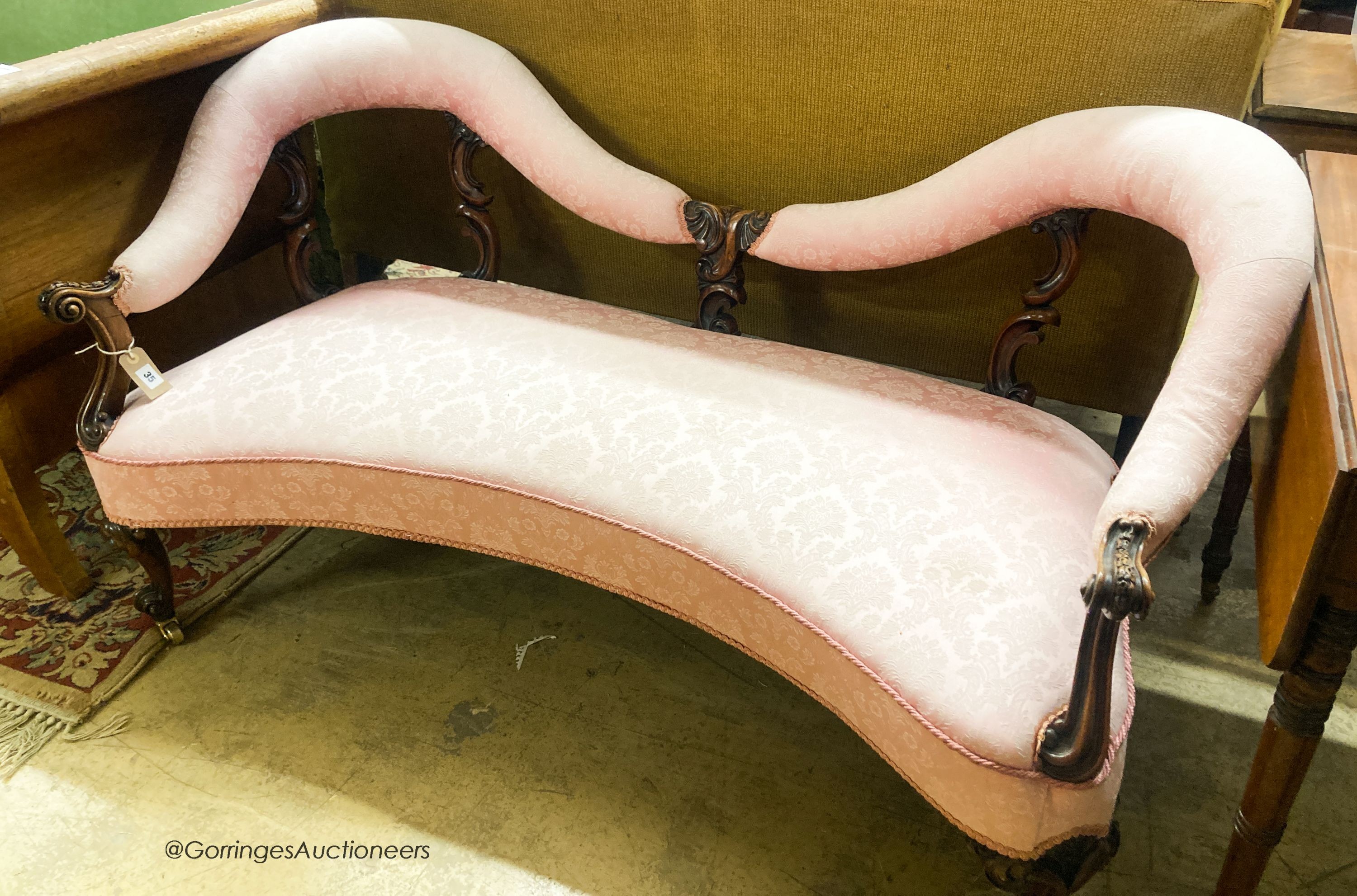 A Victorian walnut love seat, upholstered in floral damask, W.144cm. D.68cm. H.79cm
